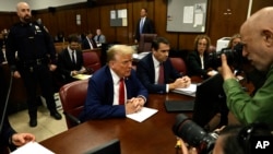 Former President Donald Trump awaits the start of his criminal trial at Manhattan criminal court in New York, May 6, 2024. 