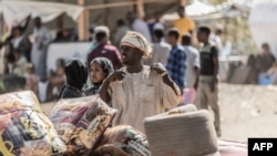 Wakimbizi waliovuka mpaka kutoka Sudan kwenda Ethiopia wakiwa na mali zao. Picha na Amanuel Sileshi/AFP.