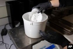 A worker measures ReAct product at Fortera's facility in San Jose, Calif., Wednesday, April 10, 2024. (AP Photo/Benjamin Fanjoy)