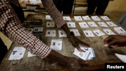 Election workers count ballot papers following a presidential election at a polling station in Dakar, Senegal, March 24, 2024.