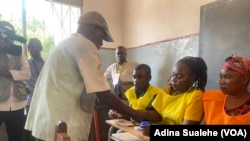 Eleitor coloca o dedo no recipiente de tinta indelével depois de descarregar o voto na urna. Eleições autárquicas, Nampula, 11 de outubro, Moçambique