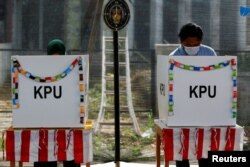 Pemilih sedang memberikan suara politik mereka di TPS saat pemilihan kepala daerah di Tangerang, Banten, 9 Desember 2020. (Foto: REUTERS/Willy Kurniawan)