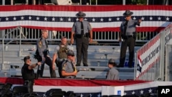 Law enforcement officers gather at the campaign rally site for Republican presidential candidate and former President Donald Trump in Butler, Pennsylvania, July 13, 2024.