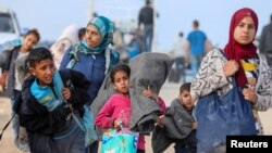 Para pengungsi Palestina berusaha untuk kembali ke rumah mereka di Gaza utara melalui pos pemeriksaan Israel, di tengah konflik antara Israel dan Hamas, seperti yang terlihat dari Jalur Gaza tengah hari Senin, 15 April 2024.