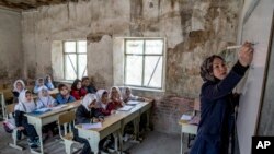 FILE - A teacher instructs young girls in Kabul, Afghanistan, March 25, 2023. The Taliban have prohibited girls from attending school beyond the sixth grade.