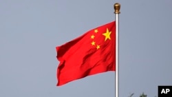 FILE - A Chinese national flag flies at Tiananmen Square in Beijing, June 14, 2018. China is taking countermeasures against two Canadian institutions and 20 people involved in human rights issues concerning the Uyghurs and Tibet.