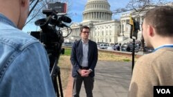 Orion Donovan Smith, center, is pictured reporting outside the Capitol for the Washington state media outlet Spokesman-Review. (Cristina Caicedo-Smit/VOA )