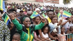 Des habitants agitent des drapeaux lors d'un défilé militaire à l'occasion de la fête de l'indépendance du Gabon, à Libreville, le 17 août 2024.