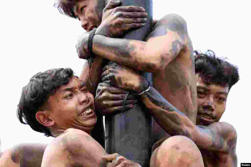 Participants try to reach the top of a greased pole to collect the prizes, during a "Panjat Pinang" competition, that is held to celebrate Indonesia's 79th Independence Day at Ancol in Jakarta, Aug. 17, 2024.