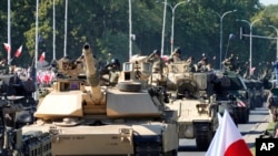 FILE - U.S.-made Abrams tanks purchased by Poland take part in a military parade in Warsaw, Poland, Aug. 15, 2023.