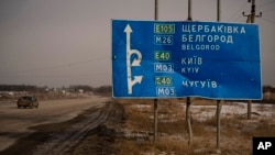 A car drives by bullet and shrapnel riddled road sign on the road to the Russian city of Belgorod, near the place where the first clashes between the Russian and Ukrainian forces took place a year ago, in Kharkiv, Ukraine, Friday, Feb. 24, 2023.