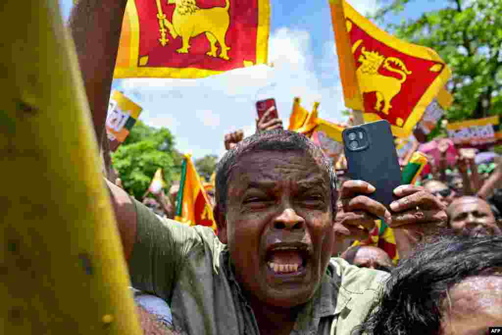 Supporters of Sri Lanka's President and United National Party presidential candidate Ranil Wickremesinghe, not pictured, cheer as he leaves the Election Commission office after filing his nomination papers for the upcoming presidential elections, in Colombo, Sri Lanka.
