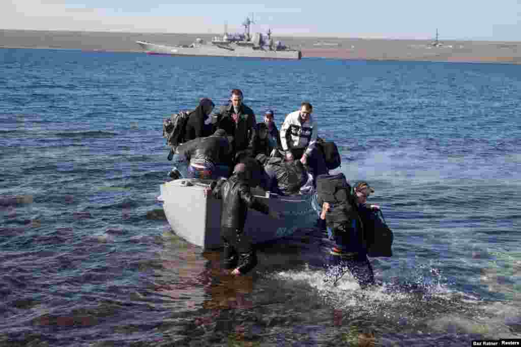 Los miembros de la tripulación del buque de guerra ucraniano Konstantin Olshansky, que fue bloqueado por buques de guerra rusos, llegan a tierra después de abandonar su barco el 23 de marzo. Posteriormente, el barco fue incautado e incorporado a la Armada rusa. Con la península de Crimea firmemente bajo control ruso, el 7 de abril el escenario estaba preparado para la guerra cuando grupos prorrusos en Donetsk y Luhansk irrumpieron en oficinas gubernamentales y se apoderaron de armamento. Kiev respondió anunciando el inicio de una operación "contraterrorista".