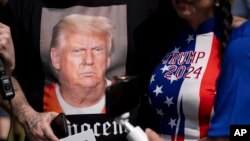 Поддржувачите на поранешниот претседател Доналд Трамп и новинарите се собираат пред затворот во округот Фултон во Атланта денес