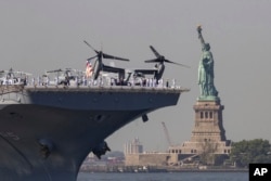 U.S. Sailors and Marines stand on the deck of the USS Bataan as it passes the Statue of Liberty during Fleet Week on Wednesday, May 22, 2024 in New York. (AP Photo/Yuki Iwamura)