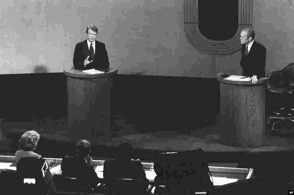 Jimmy Carter, left, talks and President Gerald Ford, right, listens during the third presidential debate at the College of William and Mary, Williamsburg, Virginia, Oct. 22, 1976.