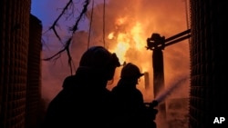 Petugas pemadam kebakaran berupaya memadamkan api di sebuah fasilitas pemasok listrik di Kharkiv, Ukraina, pada 22 Maret 2024. (Foto: AP/Yakiv Liashenko)