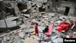 Palestinska djeca pregledavaju mjesto izraelskog napada na kuću, u Rafahu u južnom pojasu Gaze, 27. aprila 2024.