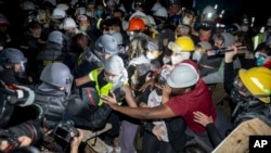 Polisi mendekati para demonstran yang mendukung Palestina di area kampus UCLA pada Kamis, 2 Mei 2024, di kota Los Angeles. (Foto: AP/Ethan Swope)
