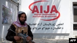 FILE - A member of Taliban security force keeps a vigil during an event organized to mark the 'World Press Freedom Day' at the office of the Afghan Independent Journalists Association (AIJA) in Kabul on May 3, 2023. 