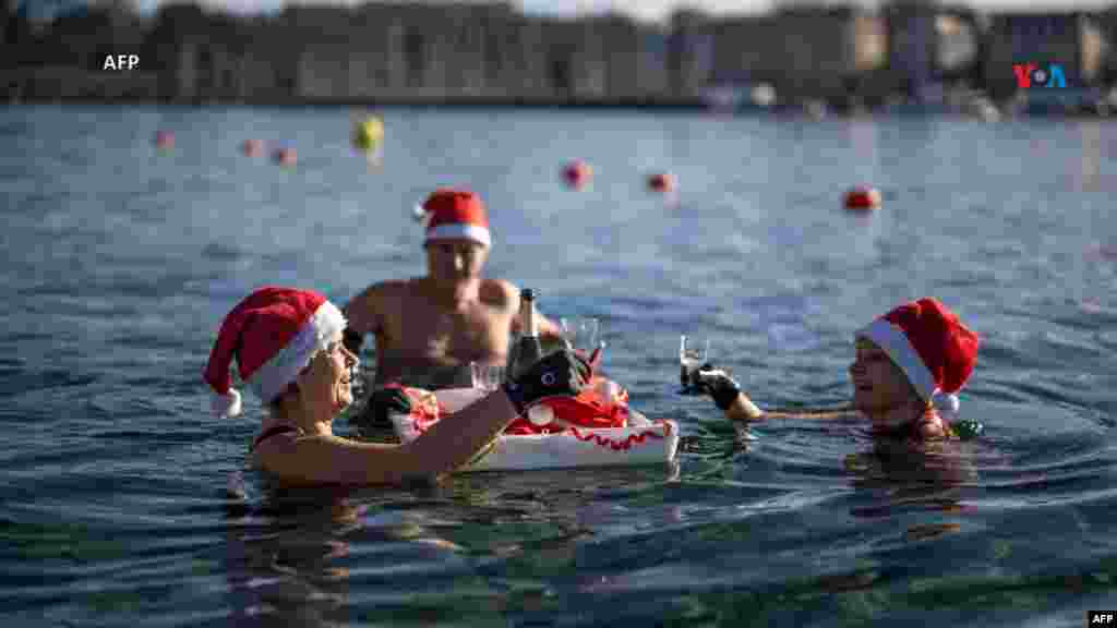 Desde Suiza: Con gorros de Papá Noel, varias personas se bañan y beben en un lago de Ginebra, a 8 grados Celsius en los baños públicos 'Bains des Paquis', en el centro de Ginebra, durante la víspera del día de Navidad, el 24 de diciembre de 2023.