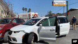 Un miembro de las fuerzas de seguridad mexicanas junto a una minivan blanca con placas de Carolina del Norte y varios agujeros de bala, donde hombres armados secuestraron a cuatro ciudadanos estadounidenses que cruzaron a México desde Texas, el viernes 3 de marzo de 2023.