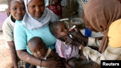 Mfanyakazi wa ustawi wa kijamii akitoa chanjo ya polio kwa mtoto huko Khartoum, tarehe 27 2007. Picha na REUTERS/Mohamed Nureldin Abdalla. 