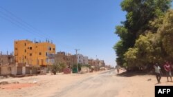 People walk along a deserted street in southern Khartoum, as violence between two rival Sudanese generals continues, on May 17, 2023.
