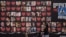 FILE - A woman and her children walk past a wall with photographs of hostages who were kidnapped during the Oct. 7, 2023, Hamas cross-border attack in Israel, on Feb. 26, 2024, in Jerusalem.