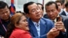 Cambodia's Prime Minister Hun Sen (C) takes selfies with a supporter during the inauguration ceremony of the Bakheng-1 water treatment plant in Phnom Penh on June 19, 2023. (Photo by TANG CHHIN Sothy / AFP)