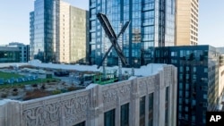 FILE - An "X" sign rests atop the company headquarters in downtown San Francisco, on July 28, 2023. Elon Musk's social media company, formerly known as Twitter, has filed a lawsuit against liberal advocacy group Media Matters. (AP Photo/Noah Berger, File)