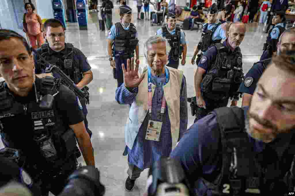 Bangladesh's finance pioneer Muhammad Yunus (C) is escorted by French police personnel as he arrives at Roissy-Charles de Gaulle Airport, north of Paris, enroute to Bangladesh, where he is set to lead a caretaker government after mass protests ousted premier Sheikh Hasina.