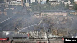 เจ้าหน้าที่กู้ภัยเร่งเข้าดับไฟที่ห้างสรรพสินค้าแห่งหนึ่งในเมืองโอเดสซา ประเทศยูเครน ที่ถูกทำลายจากการยิงโจมตีโดยกองทัพรัสเซีย เมื่อวันที่ 14 ส.ค. 2023