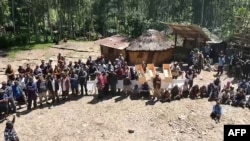 Watu wakiwa wamekusanyika baada ya maporomoko ya udongo katika kijiji cha Yambali . Picha na Emmanuel ERALIA / AFPTV / AFP. 