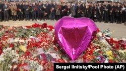 FILE - A group of ambassadors of foreign diplomatic missions visit a makeshift memorial in front of Crocus City Hall, site of a March 22, 2024, terror attack, on the outskirts of Moscow, Russia, March 30, 2024. 