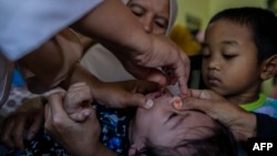 Arhiva - Zdravstvena radnica daje vakcinu Polio detetu u Bogoru, zapadna Java, Indonezija, 3. aprila 2023.