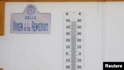 A thermometer showing 29° C (84.2° F), is seen hanging from a wall in the shadow, during the first heat alert of the year, on a hot spring day, in a street in Ronda, Spain, May 30, 2024. 