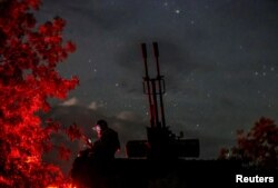 Seorang prajurit Ukraina dari unit pertahanan udara bergerak anti-drone menggunakan perangkat selulernya di dekat meriam anti pesawat ZU-23-2 di wilayah Kherson, Ukraina, 11 Juni 2024. (Foto: Reuters)