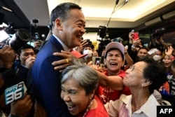 FILE - Pheu Thai Party's Srettha Thavisin, center, is hugged by supporters at the party headquarters in Bangkok, on Aug. 22, 2023.