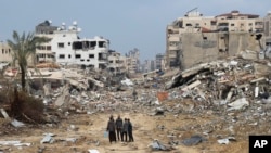 ဂါဇာကမ်းမြောင်က ဂါဇာမြို့တနေရာကို အစ္စရေးဗုံးကြဲပြီးနောက်တွေ့ရတဲ့ အဆောက်အဦးတွေနဲ့ ပါလက်စတိုင်းများ (ဇန်နဝါရီ ၃၊ ၂၀၂၄)