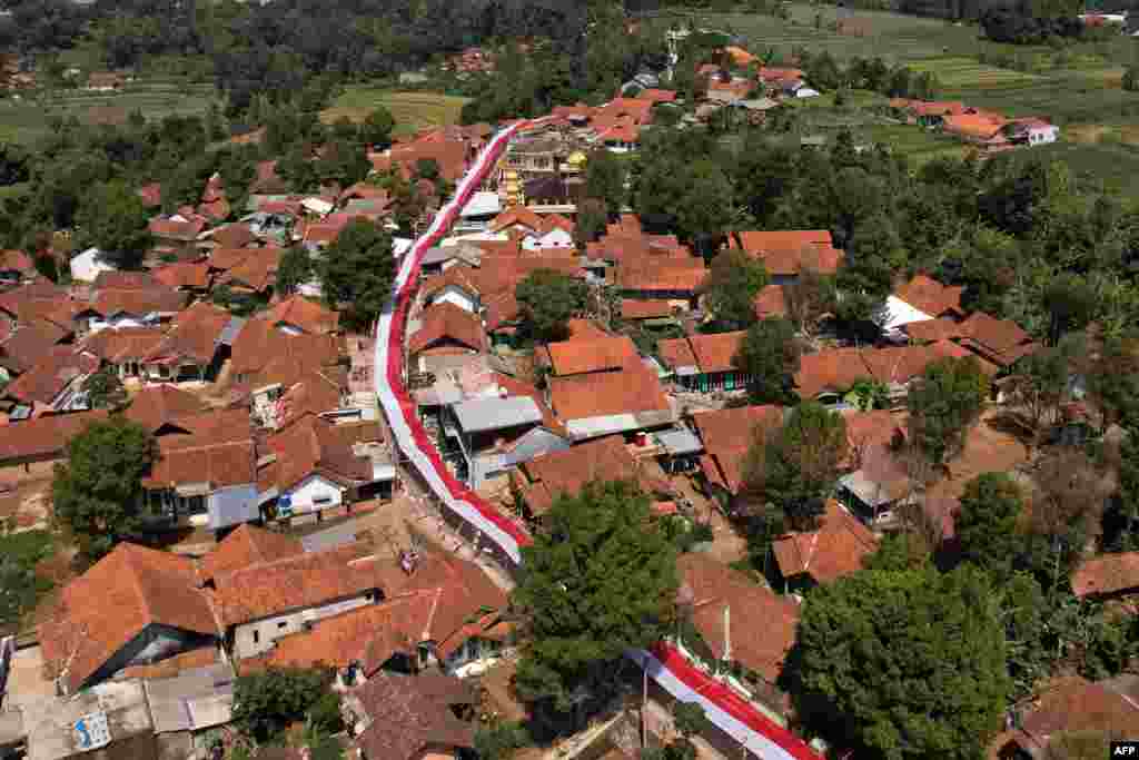 This aerial photo shows a 1000-meter-long red and white cloth, representing the colors of the Indonesian national flag, covering a road ahead of the country's Independence Day in Lemahsugih, West Java.