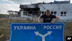 Фото: український історик тримає прикордонний дорожній знак у Суджі, AP