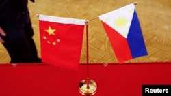 一張桌子上擺放著中國與菲律賓國旗。