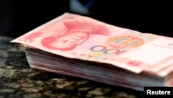 Kineske novčanice od 100 juana na šalteru filijale komercijalne banke u Pekingu, 30. marta 2016.