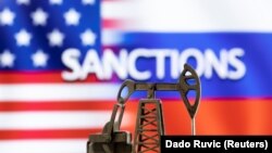 ILUSTRACIJA - Model pumpe za vađenje nafte ispred reči "Sankcije", američke i ruske zastave (Foto: Reuters/Dado Ruvić)