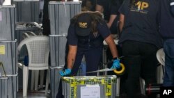 Agentes de la Fiscalía General sellan una urna de las elecciones generales del 25 de junio durante un allanamiento en una instalación temporal del Tribunal Supremo Electoral, en la Ciudad de Guatemala, el 12 de septiembre de 2023.