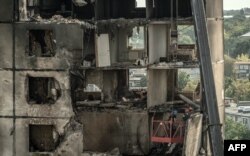 Ukrainian emergency workers inspect a heavily damaged residential building following a recent missile attack in Kharkiv, on Aug. 31, 2024.