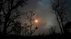 FILE - The sun sets behind the smoke of large-scale fires in the native Cerrado forest at the National Park in Brasilia, Brazil, Sept. 5, 2022.