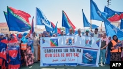 Des manifestants brandissent des bannières et des drapeaux lors d'une manifestation de soutien au gouvernement somalien suite à l'accord portuaire entre l'Éthiopie et la région séparatiste du Somaliland, le 3 janvier 2024. AFP / Abdishukri Haybe