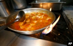 FILE - Shrimp creole is made at Antoine's Restaurant in New Orleans, in September of 2015. (AP Photo/Gerald Herbert)